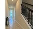 Inviting hallway features neutral walls, tiled flooring, and a staircase with a decorative railing at 2369 Palm Park Loop, Clermont, FL 34714