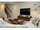 Comfortable living room space with a large TV and a cozy sectional sofa and a staircase nearby at 2369 Palm Park Loop, Clermont, FL 34714