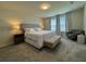 Relaxing main bedroom with a king-size bed, sitting area, and soft, natural light streaming through the windows at 2369 Palm Park Loop, Clermont, FL 34714