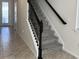 Carpeted staircase with decorative iron spindles and dark wood handrail at 2369 Palm Park Loop, Clermont, FL 34714