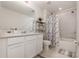 Well-lit bathroom with a marble-patterned shower curtain, white vanity, and contemporary fixtures at 2623 Buena View Rd, Kissimmee, FL 34746