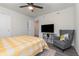 Comfortable bedroom with a TV, a cozy gray chair, and a sunny yellow and white quilt at 2623 Buena View Rd, Kissimmee, FL 34746