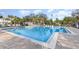 Inviting community pool with lounge seating and clear water, framed by mature trees and blue skies at 2623 Buena View Rd, Kissimmee, FL 34746