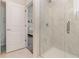 Tiled glass shower featuring brushed metal fixtures and a view into the primary bedroom at 2623 Buena View Rd, Kissimmee, FL 34746