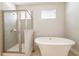 Elegant bathroom featuring a freestanding tub and a glass-enclosed shower with modern tile and fixtures at 300 Burma St, Kissimmee, FL 34747