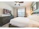 Comfortable bedroom features a large bed, dresser, TV, ceiling fan, and natural light from the window at 300 Burma St, Kissimmee, FL 34747