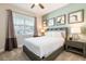 Cozy bedroom with a large window, a plush bed, and modern nightstands with lamps at 300 Burma St, Kissimmee, FL 34747