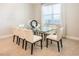 Bright dining room with a modern glass table and upholstered chairs near a window at 300 Burma St, Kissimmee, FL 34747