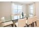 Dining room with a glass table, white chairs and great natural light through the windows at 300 Burma St, Kissimmee, FL 34747