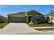 Charming one-story home featuring a well-manicured lawn and attached two-car garage at 313 Estates Ct, Haines City, FL 33844