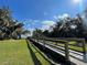 Enjoy a serene walkway through a lush landscape with mature trees and water views at 313 Estates Ct, Haines City, FL 33844