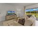 Cozy living room with plush sofa, accent chair, entertainment unit, and sliding glass doors to the outdoors at 3368 Private Oak Dr, Apopka, FL 32703