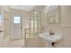 Cozy bathroom featuring a pedestal sink and a unique glass block wall that offers privacy and natural light at 345 Overstreet Ave, Longwood, FL 32750