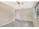 This bedroom features neutral carpet, a ceiling fan, and a window overlooking the yard at 345 Overstreet Ave, Longwood, FL 32750