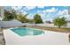 Swimming pool surrounded by a white concrete deck in a fenced backyard with a green grass at 345 Overstreet Ave, Longwood, FL 32750