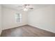 Bright bedroom with a ceiling fan, window, and wood-look flooring at 38934 Merrell Ave, Umatilla, FL 32784