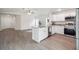 Modern kitchen with island, stainless steel appliances, and granite countertops open to living area at 38934 Merrell Ave, Umatilla, FL 32784