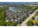 Expansive aerial view of the vibrant townhome community featuring mature trees, a pool, and a tranquil lake setting at 4008 San Gallo Dr # 102, Kissimmee, FL 34741