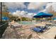 Beautiful community pool area with lounge chairs, umbrellas, and lush tropical landscaping at 4008 San Gallo Dr # 102, Kissimmee, FL 34741