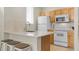 Bright kitchen featuring a breakfast bar, stainless steel sink, and white appliances at 4008 San Gallo Dr # 102, Kissimmee, FL 34741