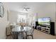 Cozy living area with a dining table, neutral decor, and a large flat-screen television at 4008 San Gallo Dr # 102, Kissimmee, FL 34741