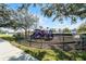 Community playground with slides and climbing structures surrounded by a black metal fence and mature trees at 4008 San Gallo Dr # 102, Kissimmee, FL 34741