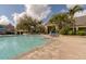 Community swimming pool with blue lounge chairs and landscaped greenery at 4008 San Gallo Dr # 102, Kissimmee, FL 34741