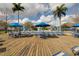 Expansive pool deck featuring lounge chairs, tables, and blue umbrellas for shade at 4008 San Gallo Dr # 102, Kissimmee, FL 34741