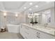 Bright bathroom showcasing a modern tub, dual sink vanity, and elegant lighting at 4651 S Atlantic Ave # 3060, Ponce Inlet, FL 32127