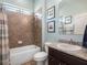 Bathroom featuring a tiled shower-over-tub combo with sink and granite counters at 4903 Eastlake Vista Dr, St Cloud, FL 34771