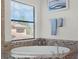Close up on bathtub with decorative tiled backsplash, wall art, and a sunlit window at 4903 Eastlake Vista Dr, St Cloud, FL 34771