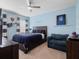 Cozy bedroom with blue walls, ceiling fan, and a comfortable full-sized bed at 4903 Eastlake Vista Dr, St Cloud, FL 34771