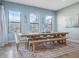 Dining room featuring a large wooden table, bench seating, and three windows with natural light at 4903 Eastlake Vista Dr, St Cloud, FL 34771