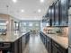 Bright kitchen featuring an island with a sink, stainless steel appliances, and dark cabinetry at 4903 Eastlake Vista Dr, St Cloud, FL 34771