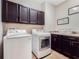 Laundry room features dark brown cabinets, white front load washer and dryer at 4903 Eastlake Vista Dr, St Cloud, FL 34771