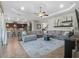 Open-concept living room featuring a large sectional sofa, ceiling fan, and decorative shelving at 4903 Eastlake Vista Dr, St Cloud, FL 34771