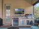 Outdoor kitchen with stainless steel appliances, mounted television, and outdoor seating at 4903 Eastlake Vista Dr, St Cloud, FL 34771