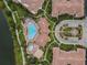 Aerial view of a community pool, hot tub, and clubhouse with meticulously landscaped grounds, plus a glimpse of the lake at 5076 Tideview Cir # 90, Orlando, FL 32819