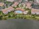 Aerial view of a community with a resort-style pool, lush landscaping, and residential buildings at 5076 Tideview Cir # 90, Orlando, FL 32819