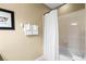 Bathroom with shower and tub combination behind a white curtain with decoratively framed artwork at 5076 Tideview Cir # 90, Orlando, FL 32819