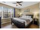 Bedroom featuring a large window and a king-size bed with sleek, dark wood accents and modern ceiling fan at 5076 Tideview Cir # 90, Orlando, FL 32819