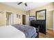 Bedroom featuring a spacious layout, ceiling fan, dark wood dresser with TV, and easy access to the hallway at 5076 Tideview Cir # 90, Orlando, FL 32819
