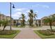 Beautiful entrance to a residential community featuring palm trees and manicured landscaping at 5076 Tideview Cir # 90, Orlando, FL 32819
