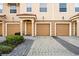 Attractive townhome featuring a two-car garage with manicured landscaping at 5076 Tideview Cir # 90, Orlando, FL 32819
