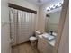Bright bathroom featuring white vanity with gold accents and shower with modern gold patterned curtain at 513 Seasons Ct, Winter Springs, FL 32708