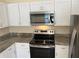 Modern kitchen showcasing stainless steel appliances, updated countertops, and white cabinetry at 513 Seasons Ct, Winter Springs, FL 32708
