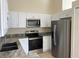 Modern kitchen features stainless steel appliances, sleek countertops, and bright white cabinetry at 513 Seasons Ct, Winter Springs, FL 32708