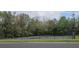 Community tennis court featuring fencing, green court surface, and surrounded by mature trees and vegetation at 513 Seasons Ct, Winter Springs, FL 32708