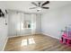 Bedroom featuring wood-look floors, a ceiling fan and white curtains at 583 Treehouse St, Winter Springs, FL 32708