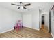 Bedroom with wood-look floors, ceiling fan, closet, and a pink dollhouse at 583 Treehouse St, Winter Springs, FL 32708